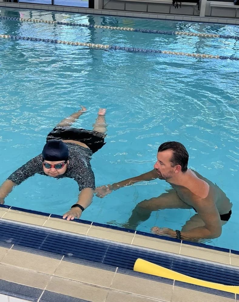 Jason Cram in the water guiding an adult through a glide