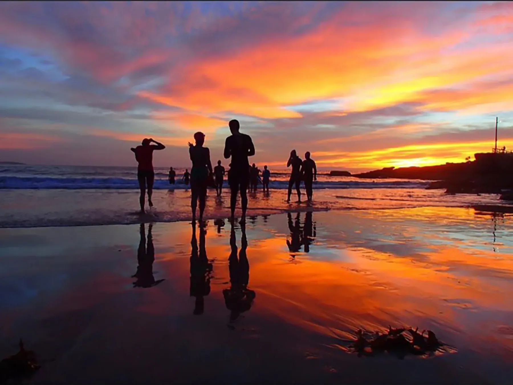 A swimmer heading into the ocean at sunrise